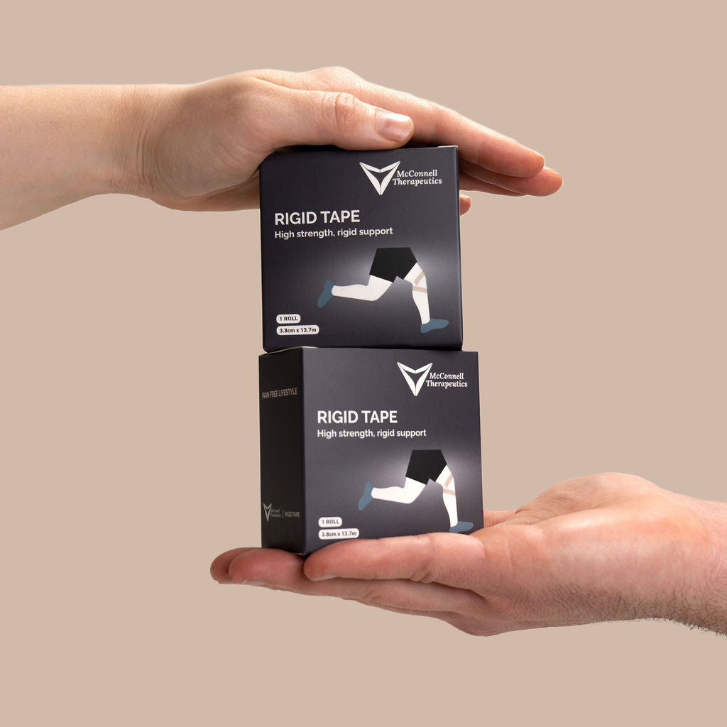 Clinician holding McConnell Therapeutics Rigid Tape boxes demonstrating compact clinic packaging