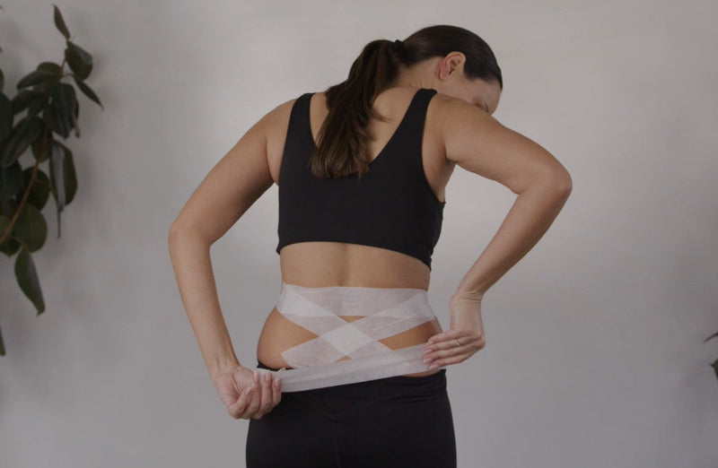 Applying McConnell taping to the lower back for pain relief and spinal stability support