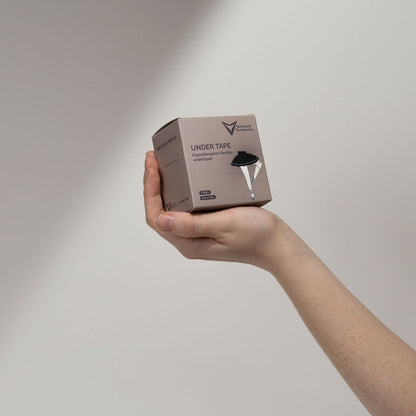 Clinician holding McConnell Therapeutics Under Tape box demonstrating compact clinic packaging